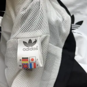 Trench coat com capuz Adidas preto e branco